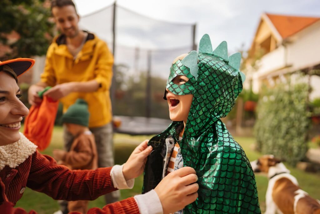 a child laughs while putting on his Halloween costume