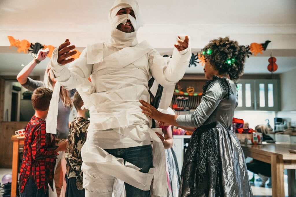a man prepares his mummy costume with his children